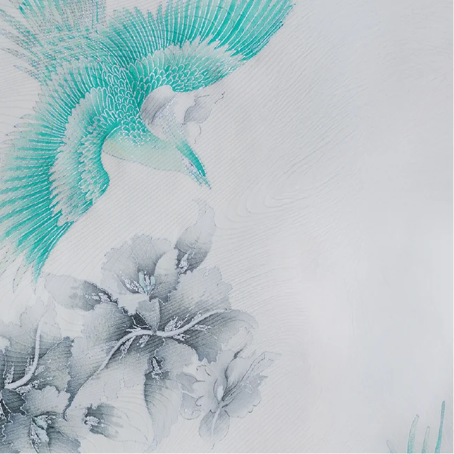 生成り地に翼を広げた青緑の鳥を大きく配し、画面下部に淡い灰色の花々を描いた七五三着物の生地クローズアップ。右側に余白を残した構図。