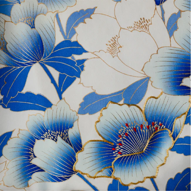 青と白の大輪牡丹を描いた着物地のクローズアップ — 金の輪郭線で縁取られ、花芯に赤い差し色を配し、生地全体に花柄が広がる構図。