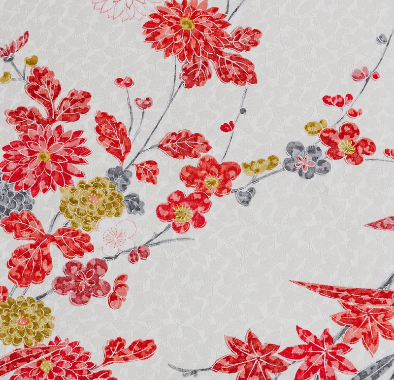白地に地紋を施した着物生地の接写 — 赤い菊や梅、灰色の花、金色の花を枝に配し、紅葉も添えた花柄が斜めに広がる構図。